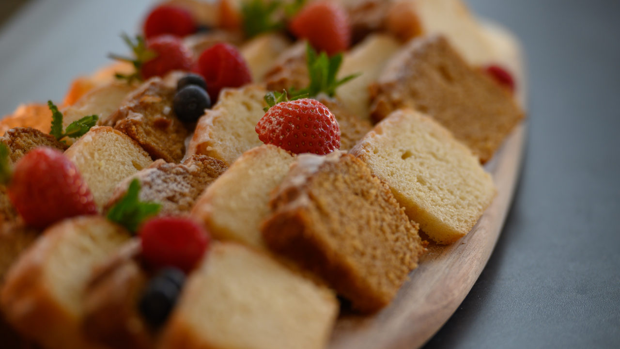 A plate of small pieces of cake and strawberries